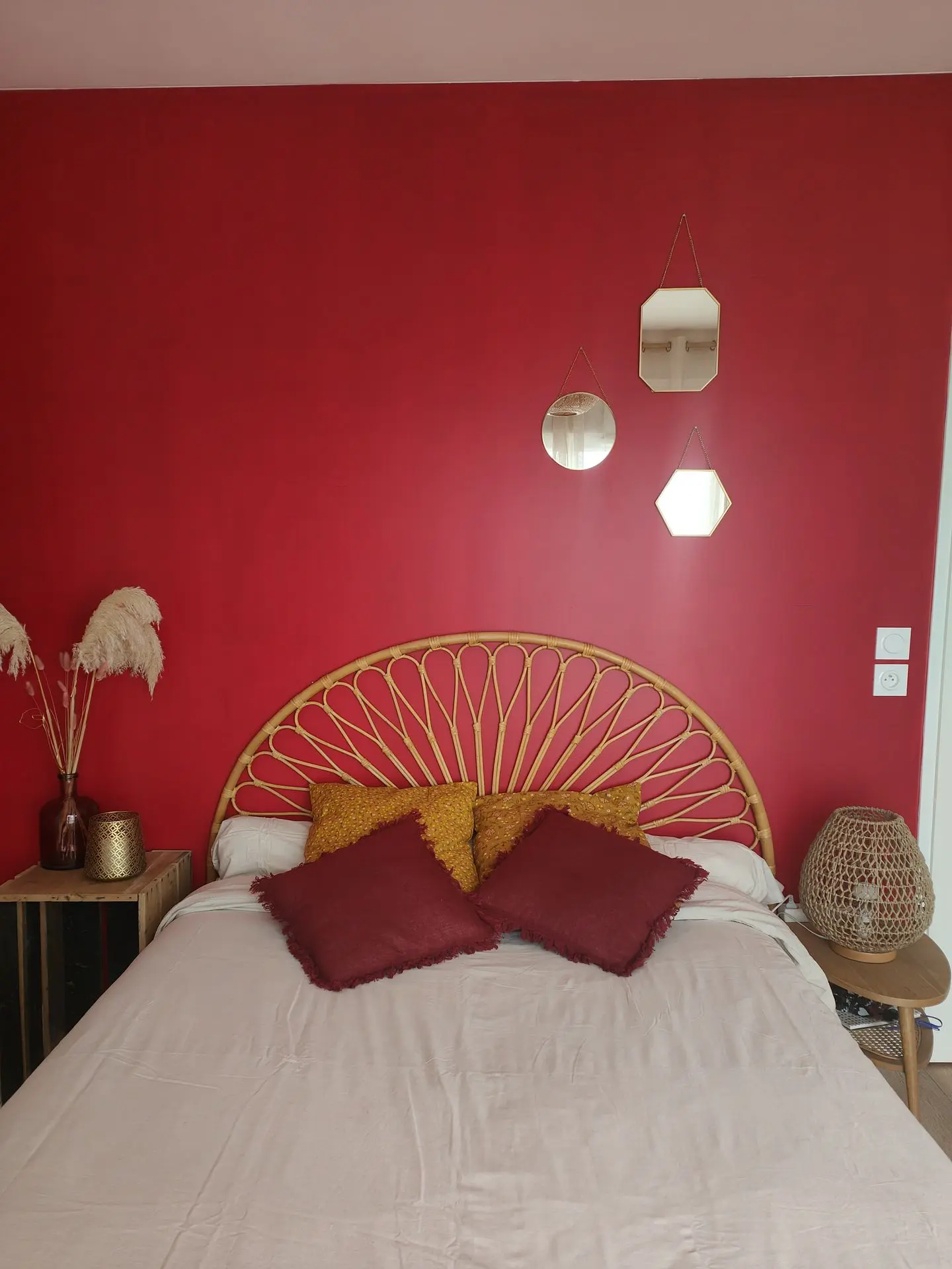 Chambre parentale avec un mur rougeavec du mobilier de seconde main et de l'ameublement créait en DIY